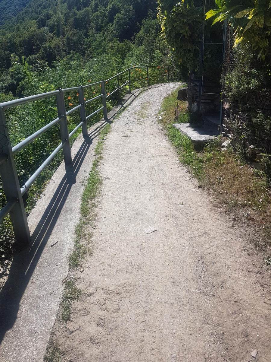 Fenced gravel path along a valley route near Cannobio