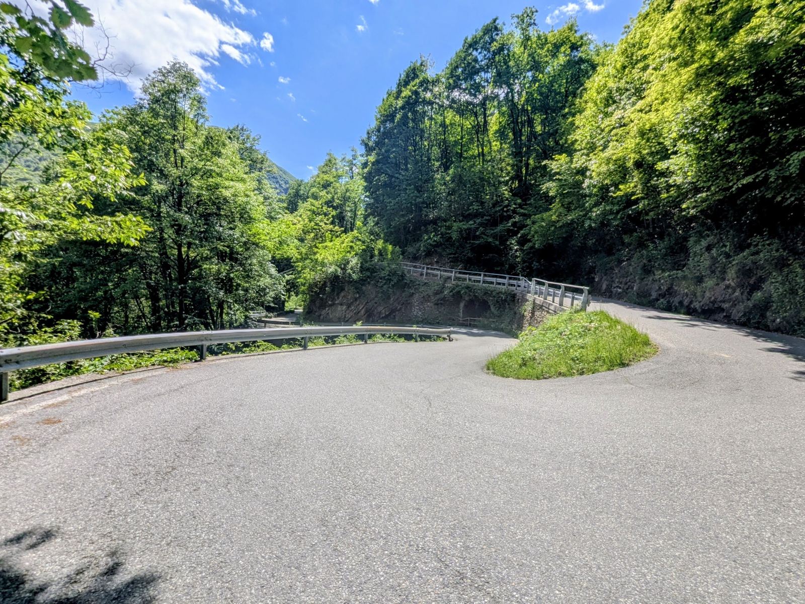 A tight hairpin bend with a guardrail on the narrow road climbing out of the Cannobino valley above Cannobio
