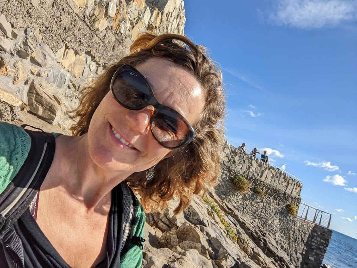 My wife at a clifftop stop along the Ligurian coast path, sea and rocks in the background