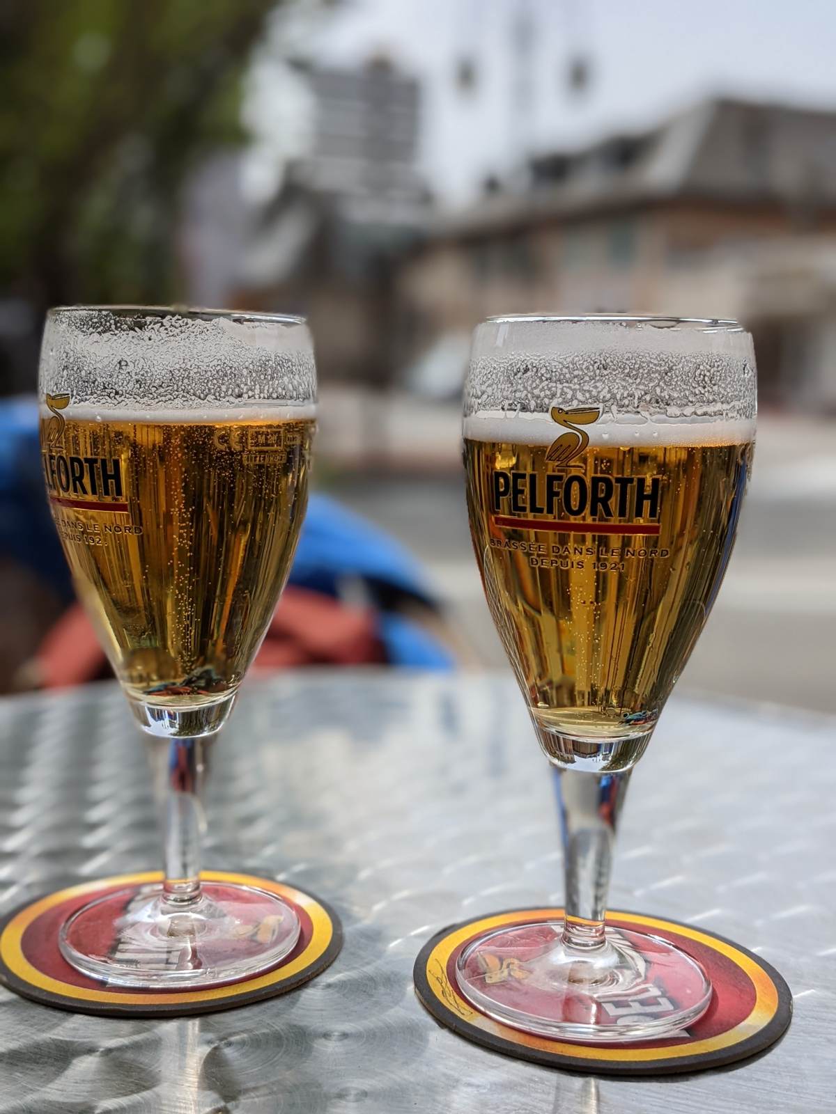 Two Pelforth beers on a café table in the French Alps