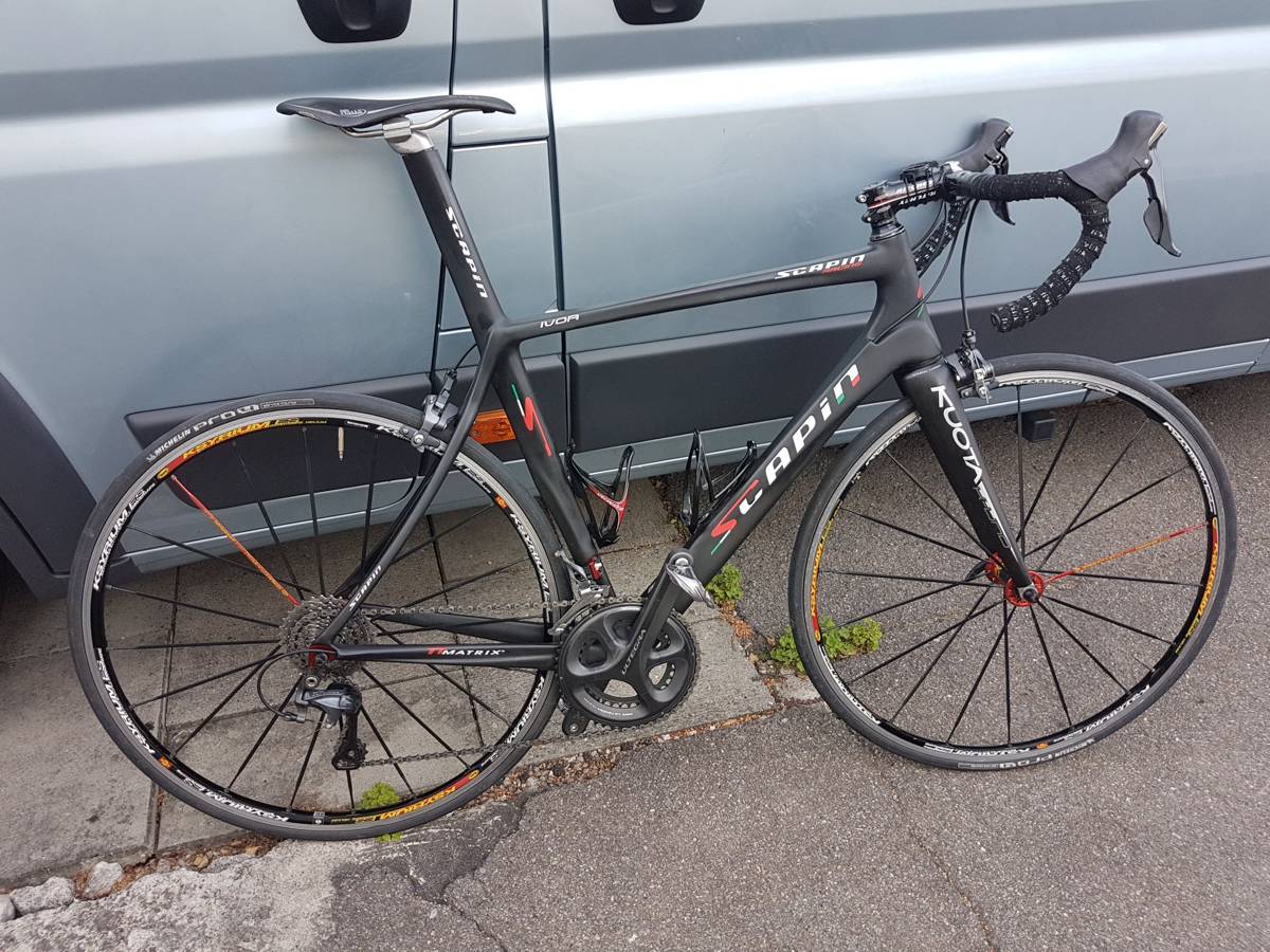 A road bike leaning against a motorhome before a ride in the Jura