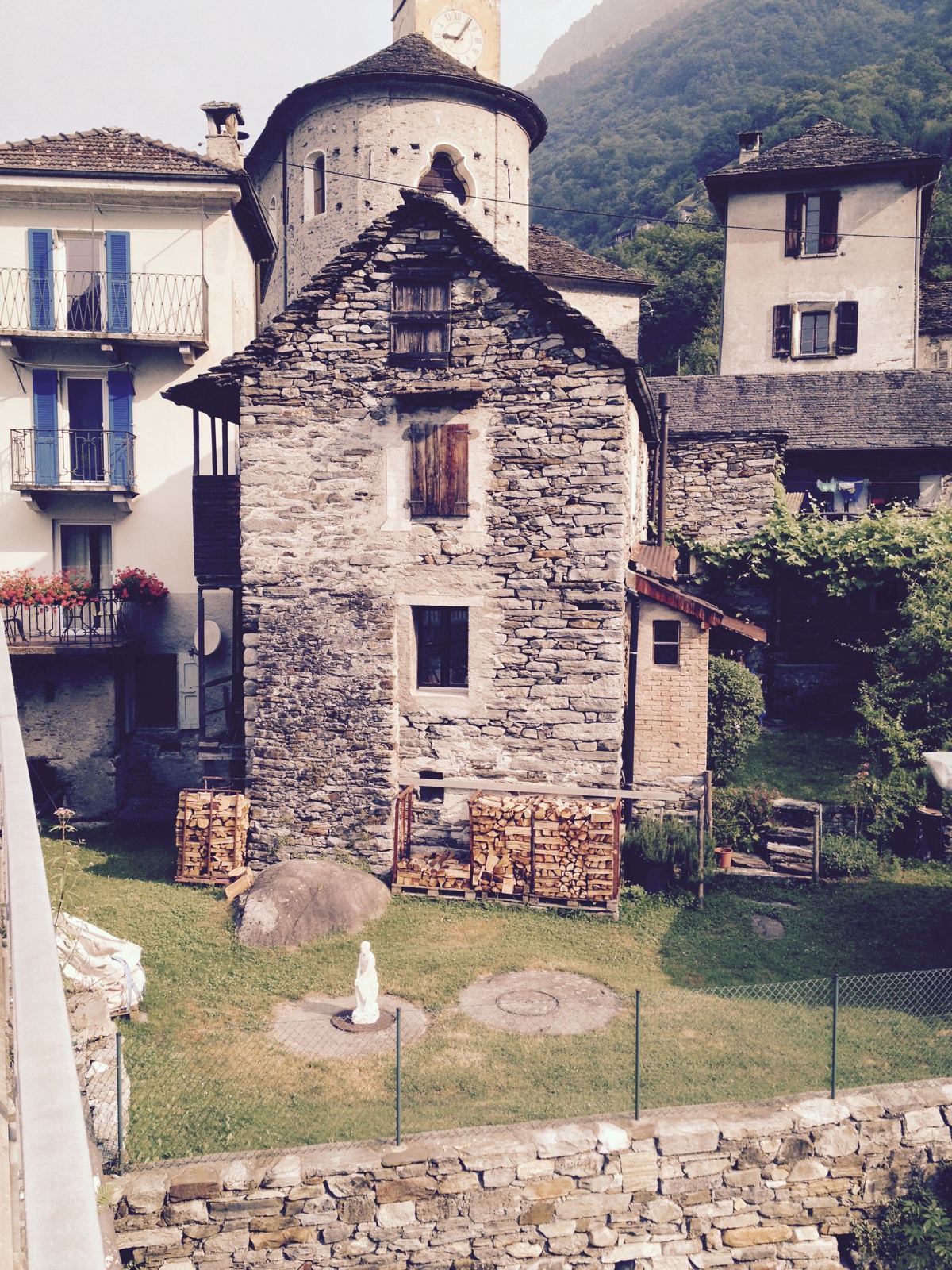 A stone tower house and church in Corippo, Verzasca Valley, Ticino, Switzerland